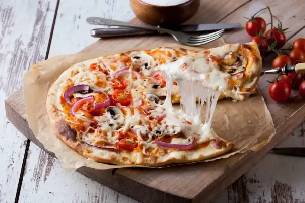 Pyszna pizza 32 cm z ciągnącym serem, pomidorkami i cebulą. Zastanawiasz się, ile gram ciasta na pizzę 32 cm? To idealna porcja!