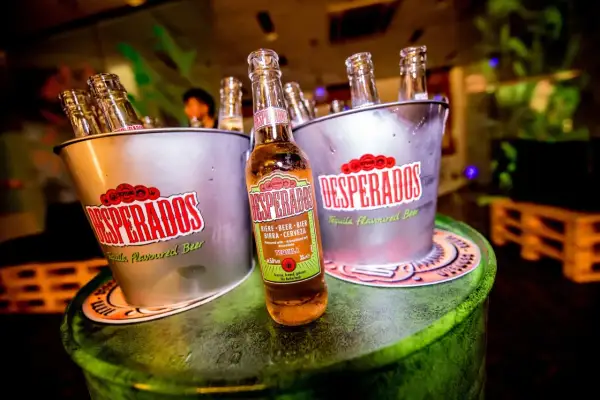 Butelki Desperados w wiaderkach, jedna z nich pokazuje zawartość alkoholu 5,9% vol.