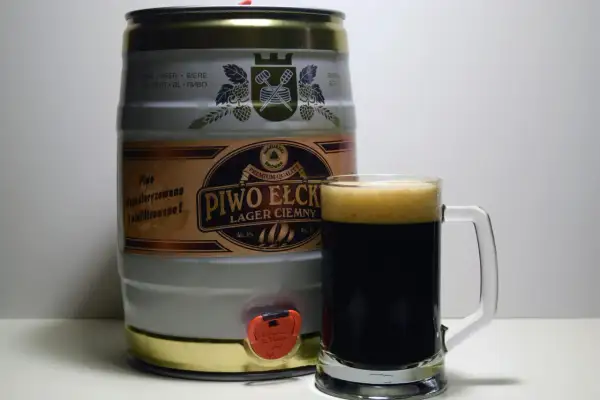 Beczka z piwem Ełckim Lager Ciemny i kufel pełen dunkel piwa. Idealne na wieczorne spotkanie.