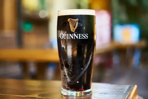 Szklanka Guinnessa, ciemnego piwa z pianką, którego barwa i smak wynikają ze słodu jęczmiennego.
