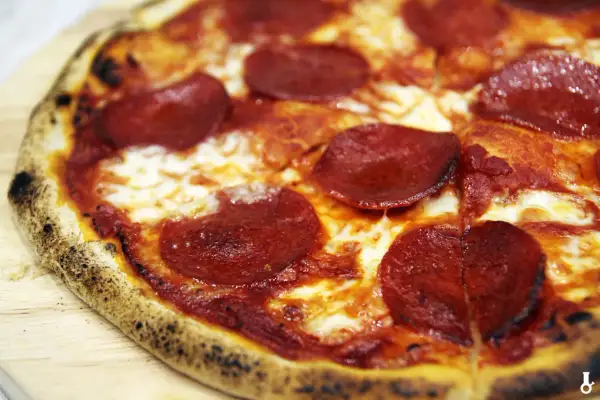 Pyszna pizza pepperoni z ciągnącym serem. Czy można przygotować pizzę wcześniej? Tak, można ją upiec i odgrzać.