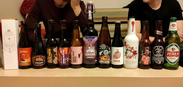 Rząd butelek z piwem, w tym mocne piwo, z etykietami "Piwojad", "Baltic Porter", "Imperial Pastry Stout", "Szkockie", "Igroki" i "Perła".