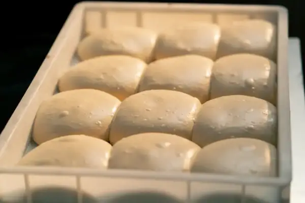 Gotowe do pieczenia ciasto na pizzę w lodówce. Porcje ciasta czekają na swoją kolej, by stać się pyszną pizzą.