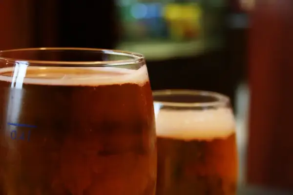 Dwa szklanki piwa, z pianką i bąbelkami. Na pierwszej widać oznaczenie 0,4l. Idealny piwny zacier na wieczór.