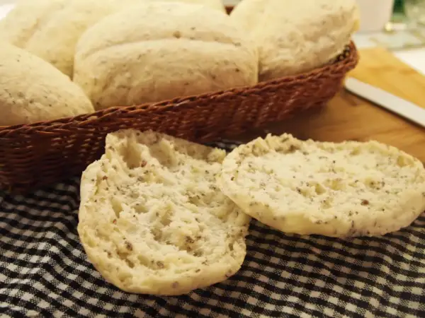 Puszyste bułki bezglutenowe, idealne na śniadanie, leżą w koszyku i na czarno-białej kratce.