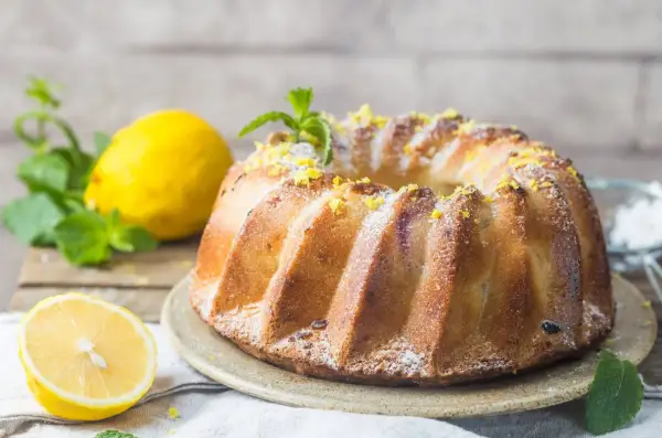 Złocista, pachnąca cytryną babka serowa, posypana cukrem pudrem i skórką cytrynową, z listkami mięty. To najlepsza babka serowa na świecie!