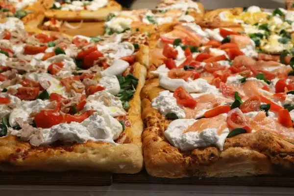 Puszyste brzegi pizzy z burratą, pomidorkami i łososiem lub tuńczykiem.