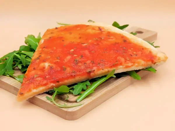Kawałek pizzy marinara na desce z rukolą. Zastanawiasz się nad pizza marinara kcal?