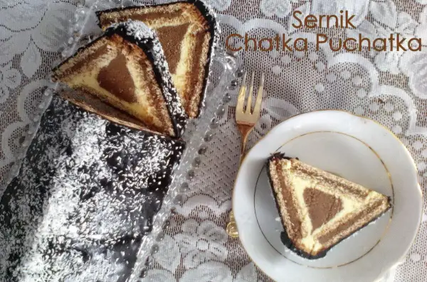 Sernik Chatka Puchatka, udekorowany czekoladą i wiórkami kokosowymi, wygląda pysznie. Kawałek na talerzyku zachęca do spróbowania.